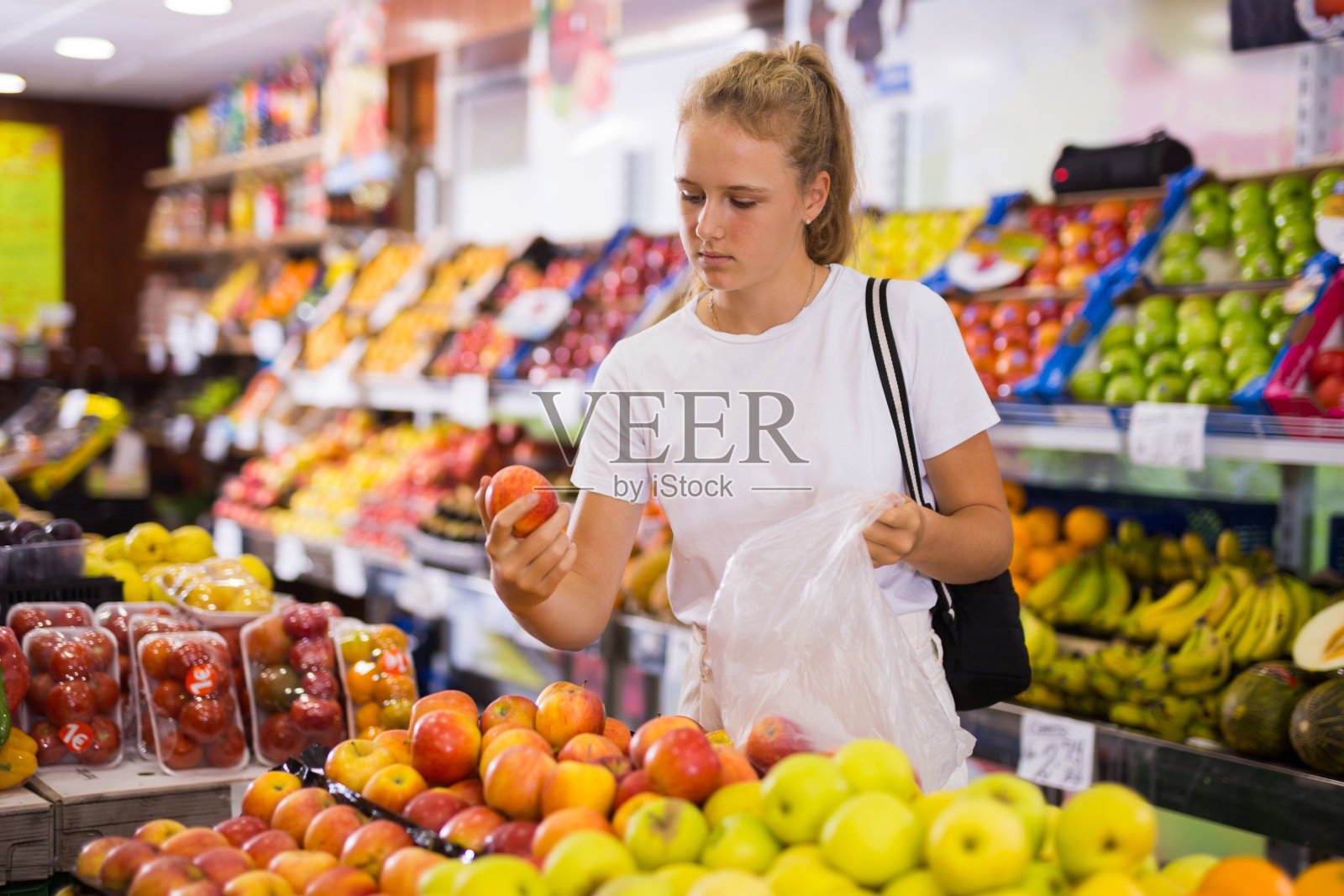 专注的15岁女孩选择成熟的苹果照片摄影图片