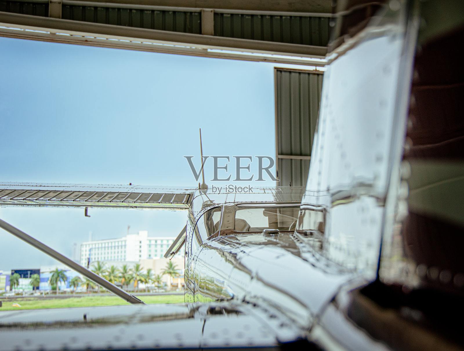 侧面拍摄的现代白色飞机反射窗户玻璃的土地与蓝色的天空照片摄影图片