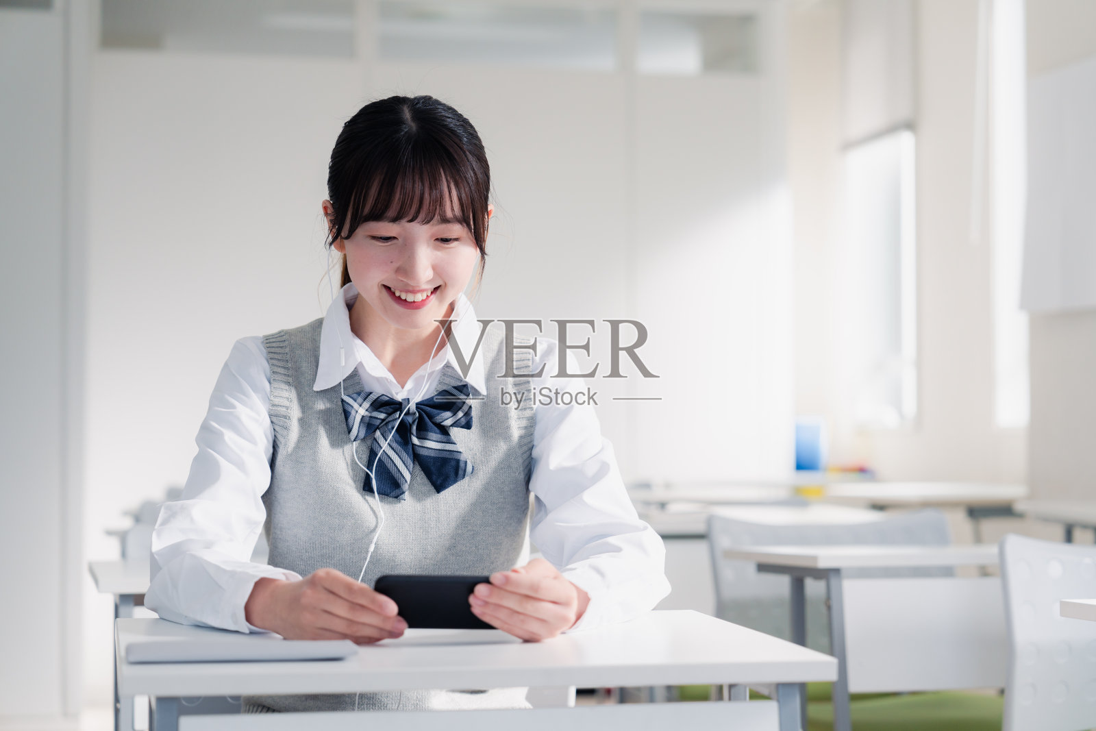 高中女生用智能手机看视频照片摄影图片