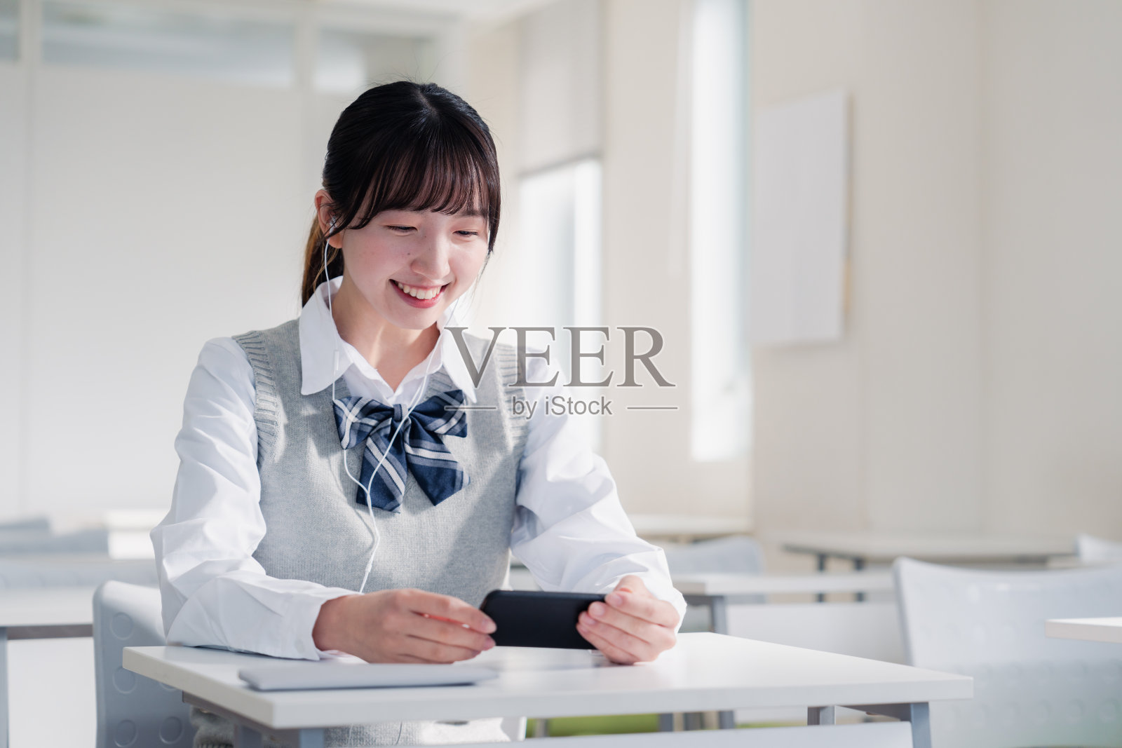 高中女生用智能手机看视频照片摄影图片