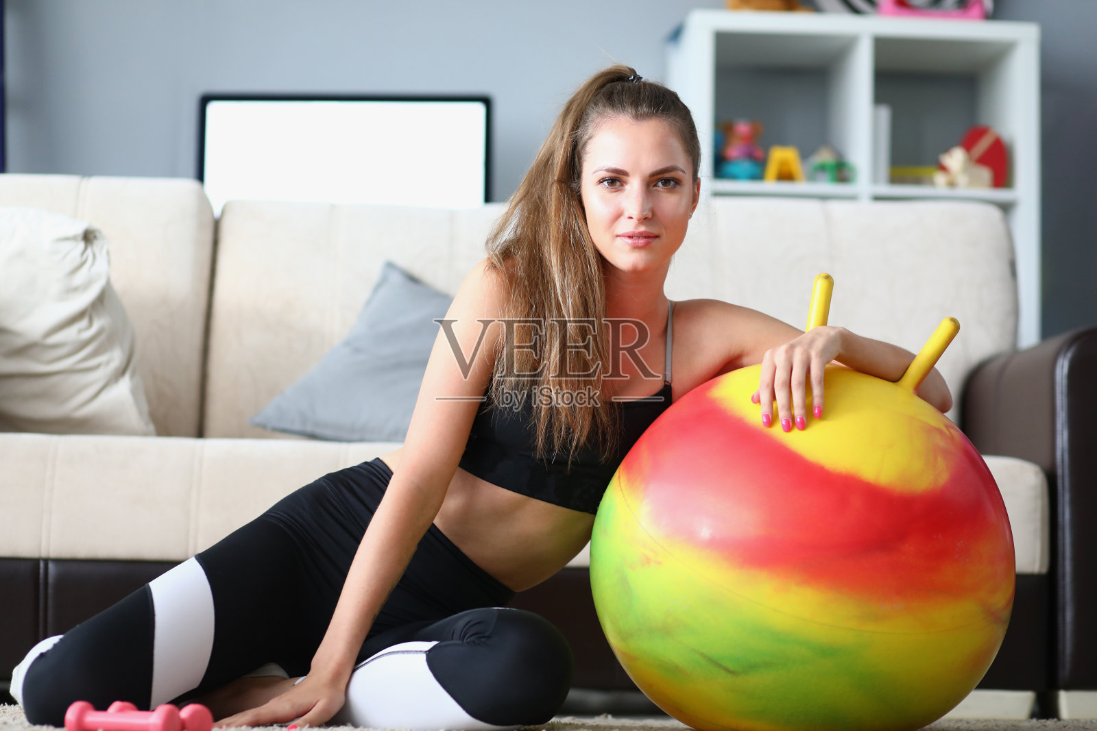 美丽的微笑女士锻炼在家里的健身球照片摄影图片