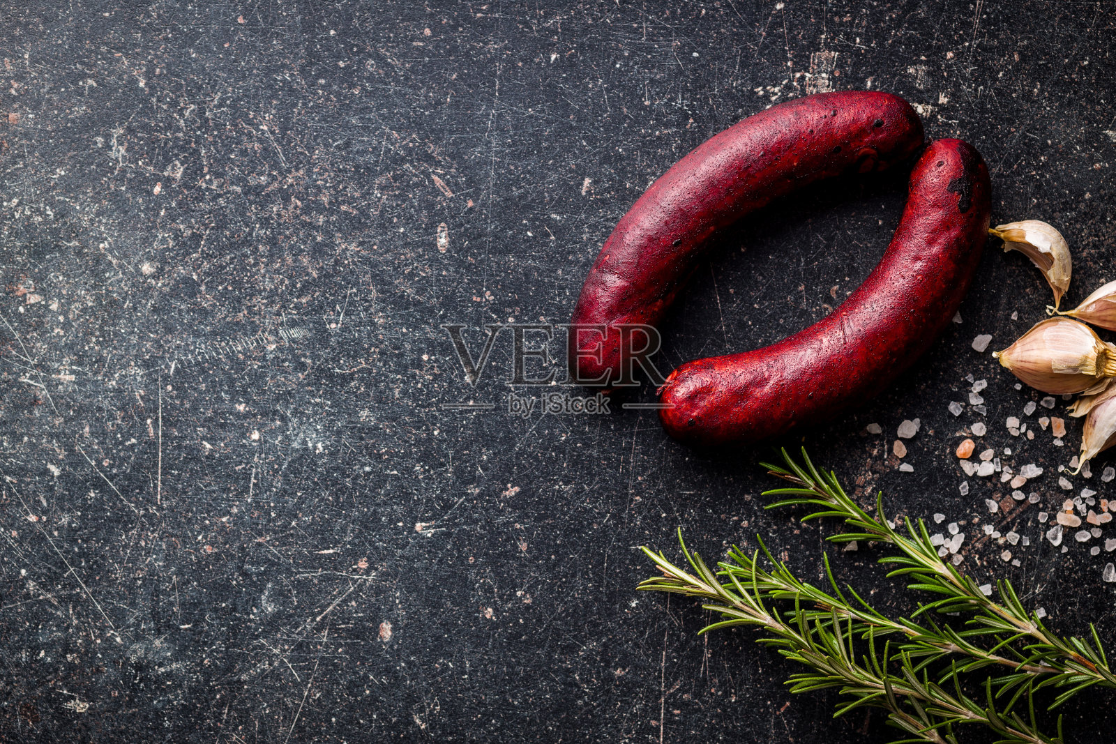 黑桌子上的烟熏猪肉香肠。照片摄影图片