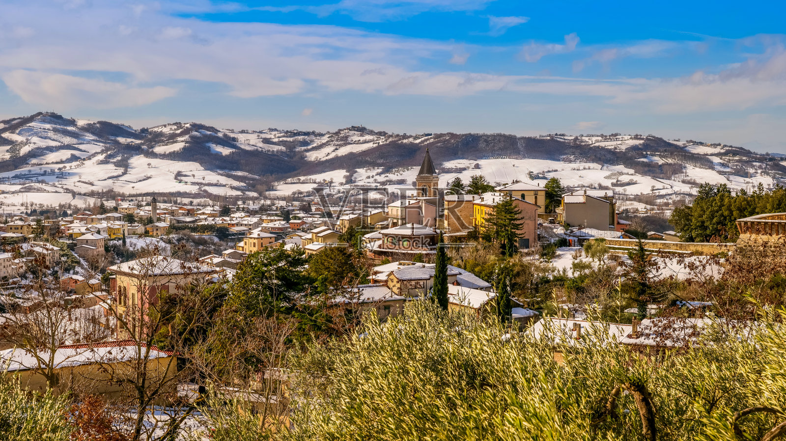 翁布里亚(Umbria)一个中世纪村庄的壮丽冬季风光，位于雪山和森林之间照片摄影图片