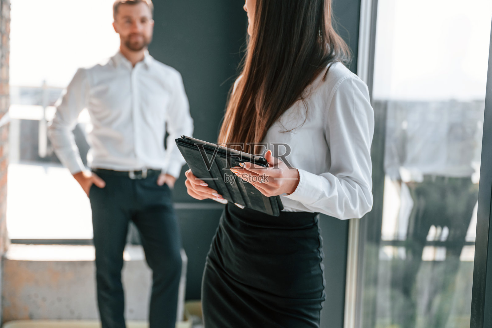 手里拿着文件站着。工业工人白天在大楼里工作。建设地点照片摄影图片