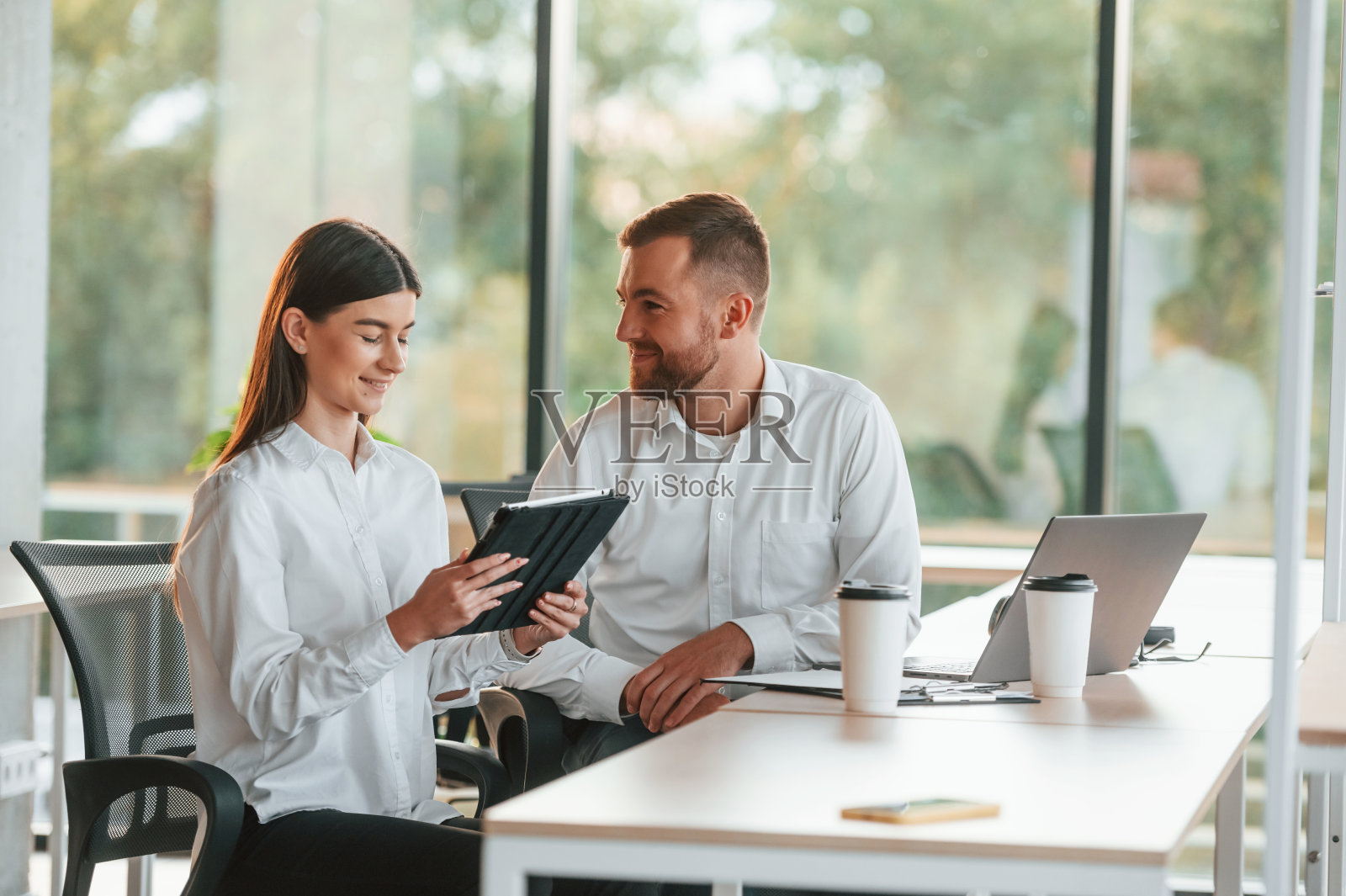 分享想法。男人和女人一起在现代化的办公室里工作照片摄影图片