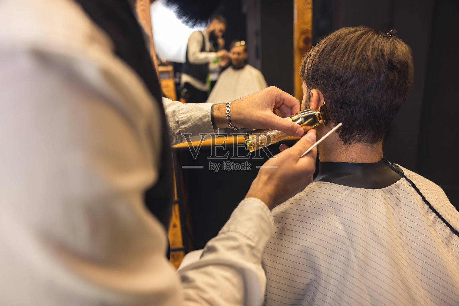 理发师细心地为顾客修剪头发照片摄影图片
