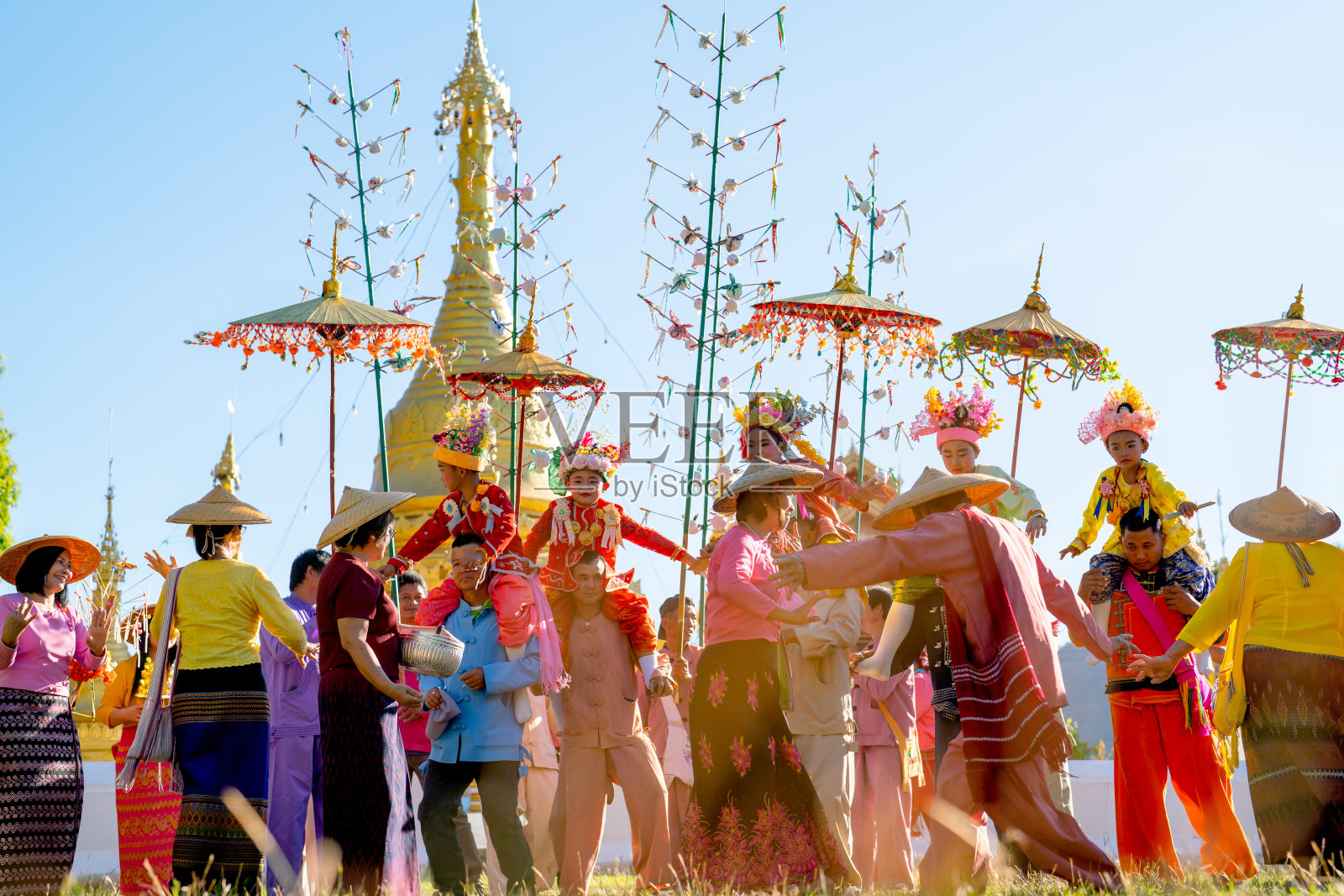 一群爱山人在寺庙区域的金塔前庆祝和享受泰国北方的传统活动。它的名字Poi Sang Long与年轻的佛教新手僧人有关。照片摄影图片