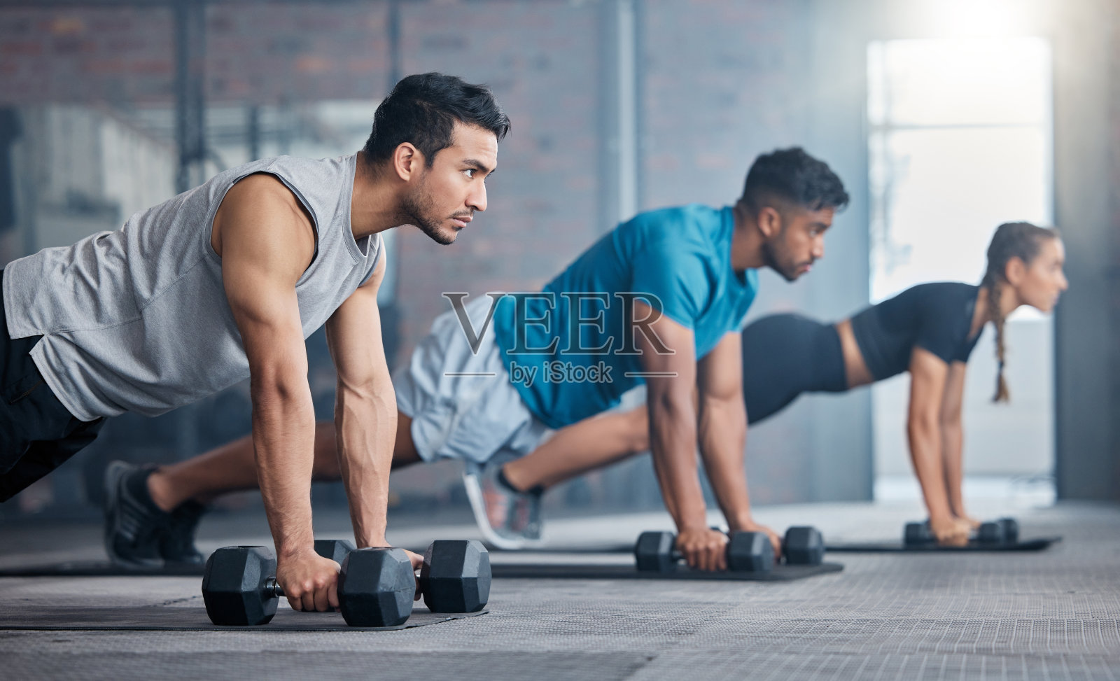 健身房，哑铃平板支撑和人们专注于健身饮食，身体健康目标或表现健康承诺。运动激励，班级运动挑战和运动员团队训练在运动俱乐部楼层照片摄影图片