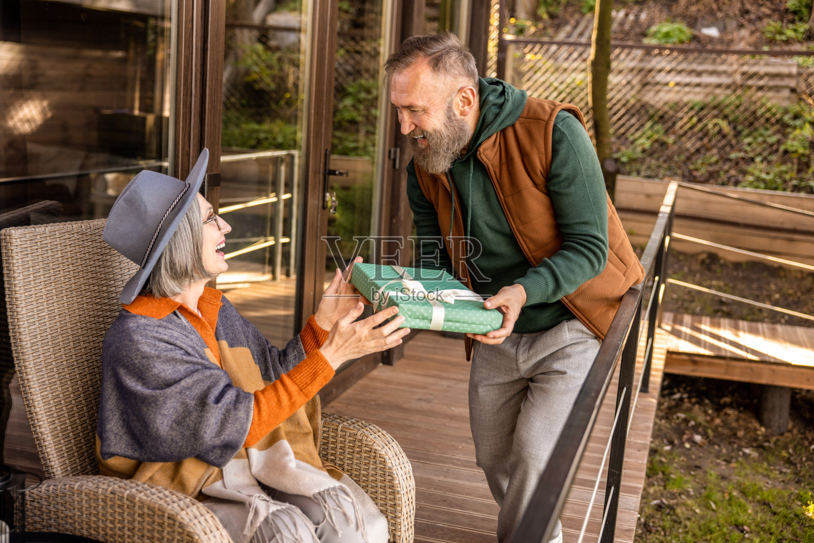 微笑的男人给他的妻子礼物，看起来很高兴照片摄影图片