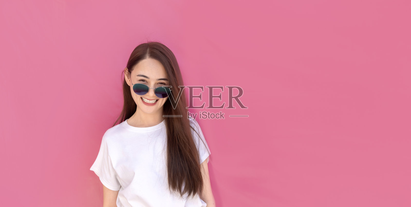 时髦的长发亚洲女人快乐和微笑的白衬衫和太阳镜照片摄影图片