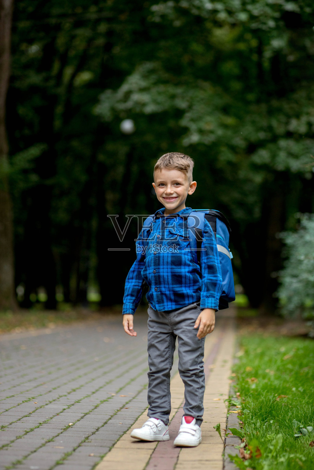 一个背着背包的一年级学生的肖像。男孩去上学了照片摄影图片