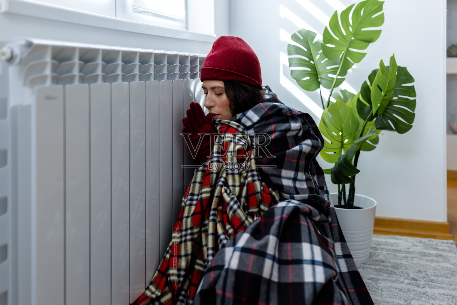 一个年轻女子正在经历能源危机，在公寓里感到寒冷。照片摄影图片