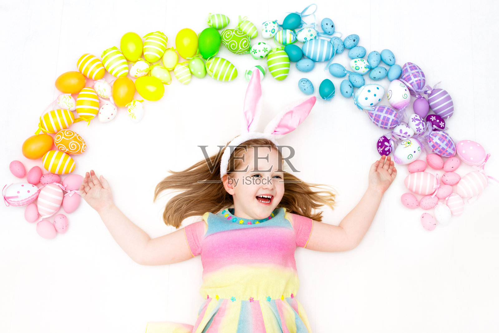 寻找复活节彩蛋的孩子。色彩柔和的彩虹蛋。照片摄影图片