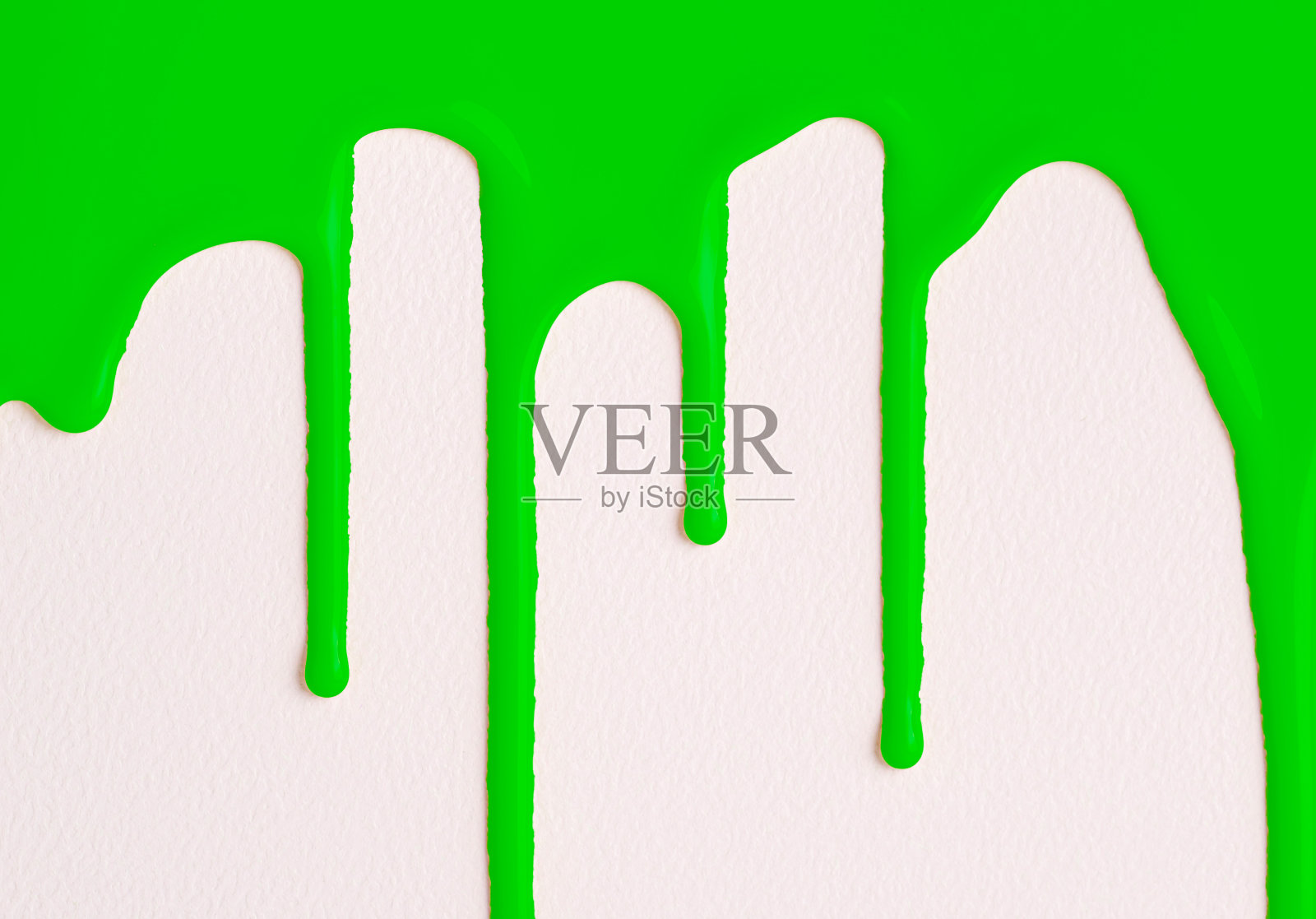 绿色的颜料滴在白色的画布上。抽象艺术。绿色的油漆滴落在白色的墙上，有复制的空间。照片摄影图片