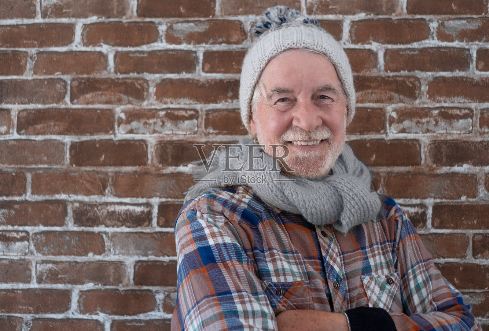 画像英俊的成人成熟的微笑高级男子站在冬天的衣服孤立的砖背景。年轻的潮人年长的大胡子祖父与格子衬衫照片摄影图片