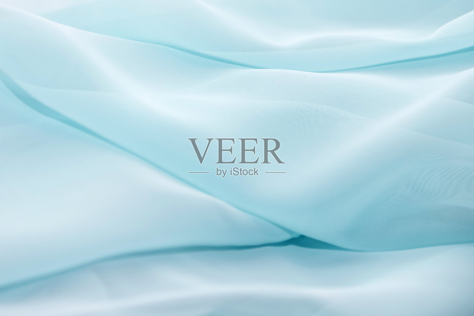 作为背景的淡蓝色雪纺织物的波浪状表面的纹理。透视照片照片摄影图片