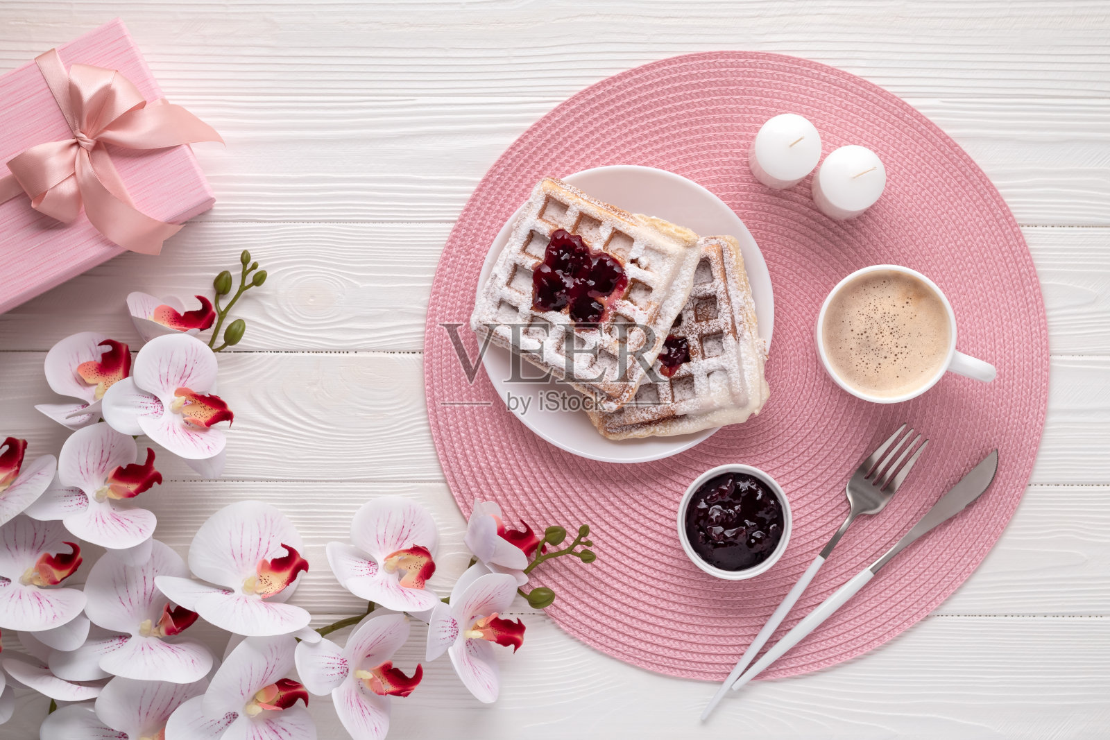 比利时华夫饼配拿铁和兰花放在白色木桌上。前视图。母亲节贺卡。饮食背景。早上早餐有咖啡和甜点。节日的花束。生活方式照片摄影图片