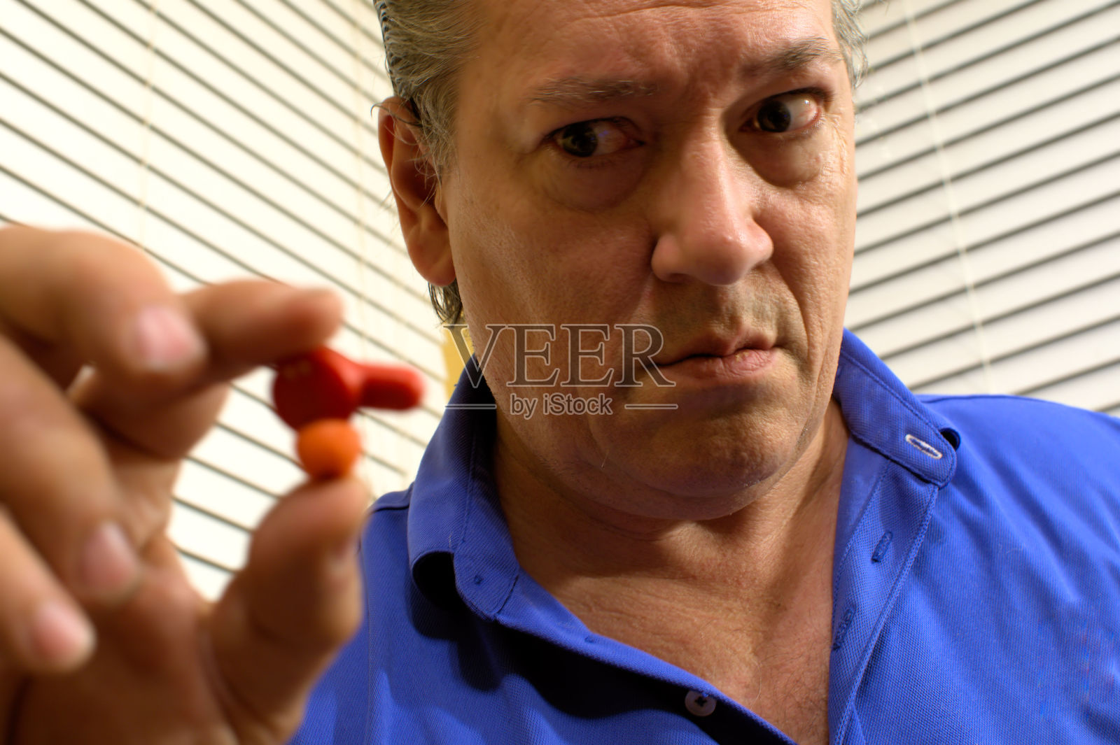 一名中年男子茫然地看着耳机扬声器。照片摄影图片