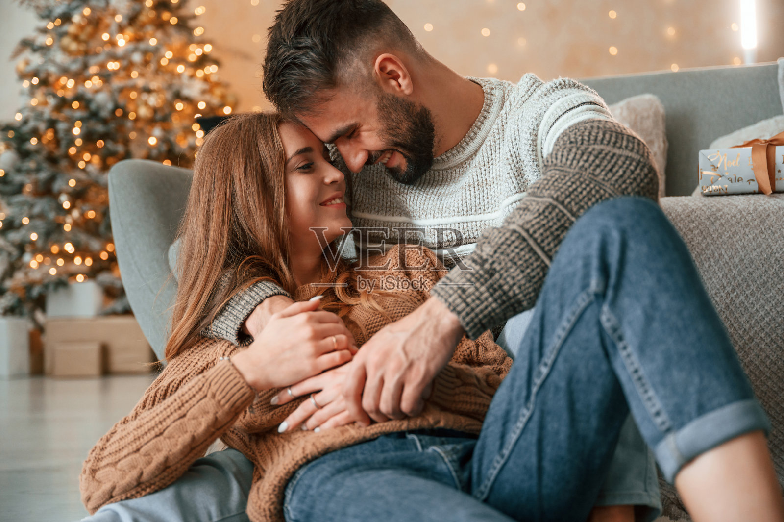 躺在沙发上拥抱。可爱的小情侣正在家里庆祝新年照片摄影图片