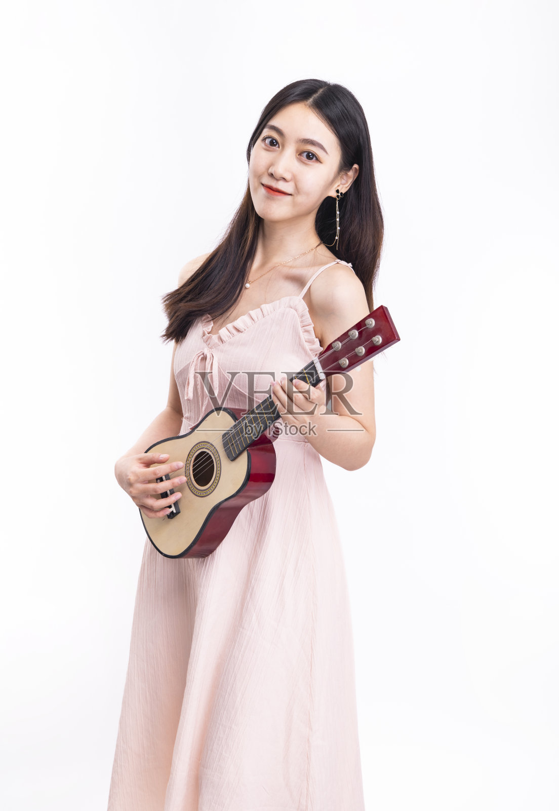 那个穿粉色裙子拿着尤克里里的女孩照片摄影图片