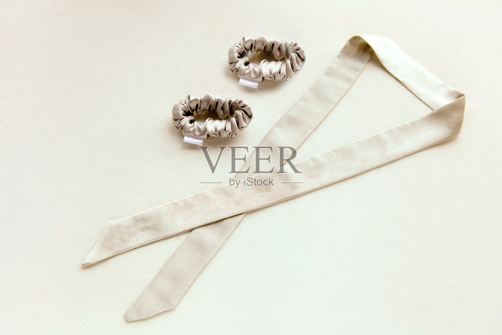 米色丝质带子和发圈或发带。奢华的美发工具，适合所有类型的女孩。照片摄影图片