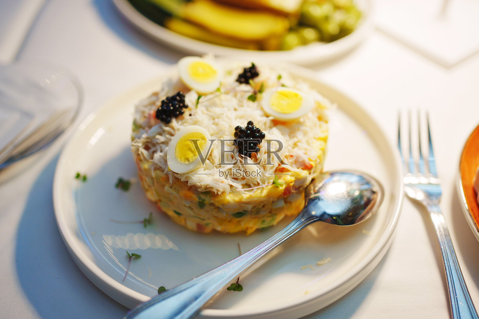 表设置。沙拉配海鲜和鹌鹑蛋，放在圆盘子里。照片摄影图片