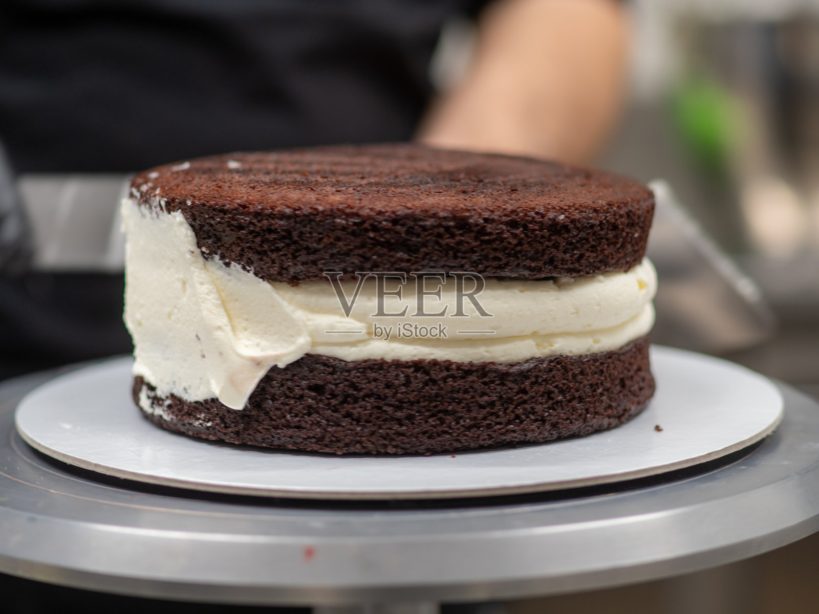 糕点设计师厨师制作了一个三层的黑巧克力蛋糕，里面有浆果和奶油照片摄影图片