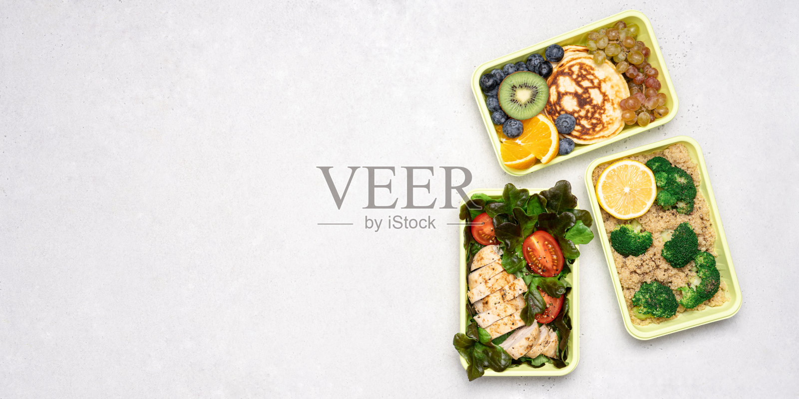 早餐，午餐，晚餐都装在白色背景的绿色可回收容器里照片摄影图片