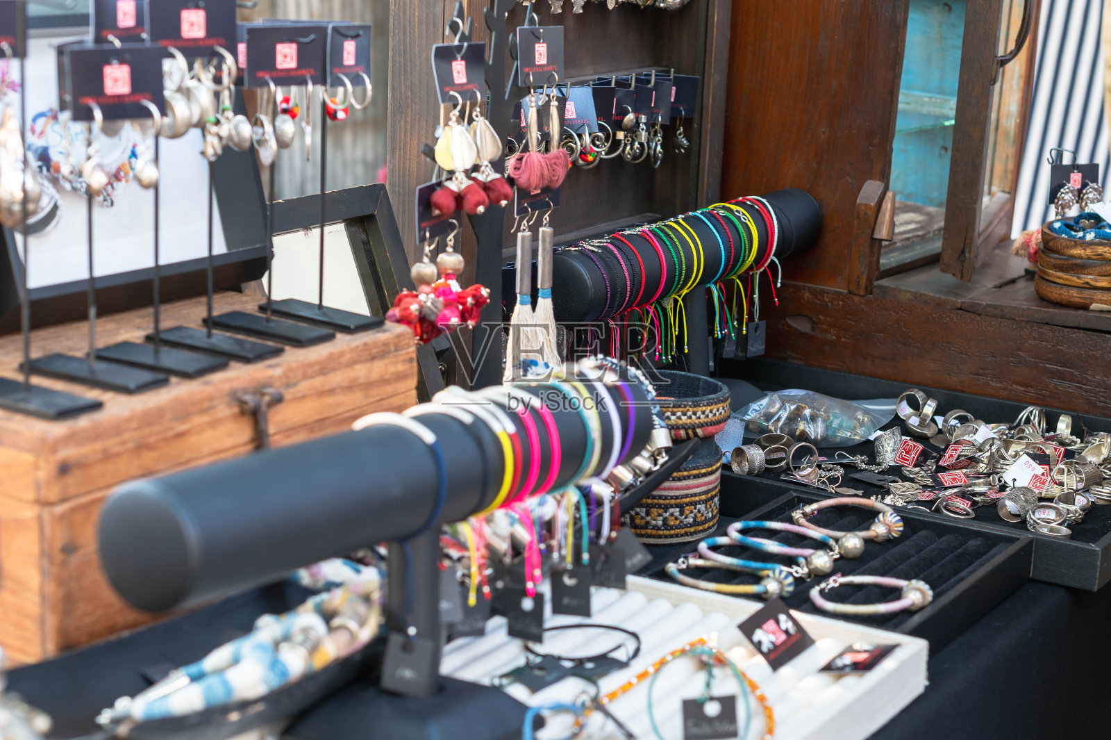 女售货员在桌子上摆好首饰，准备在泰国当地市场卖给顾客。照片摄影图片