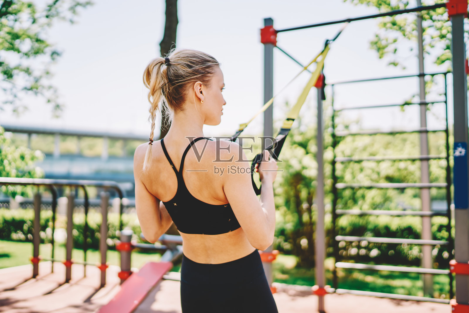 运动的女人做锻炼使用悬挂带在大自然照片摄影图片