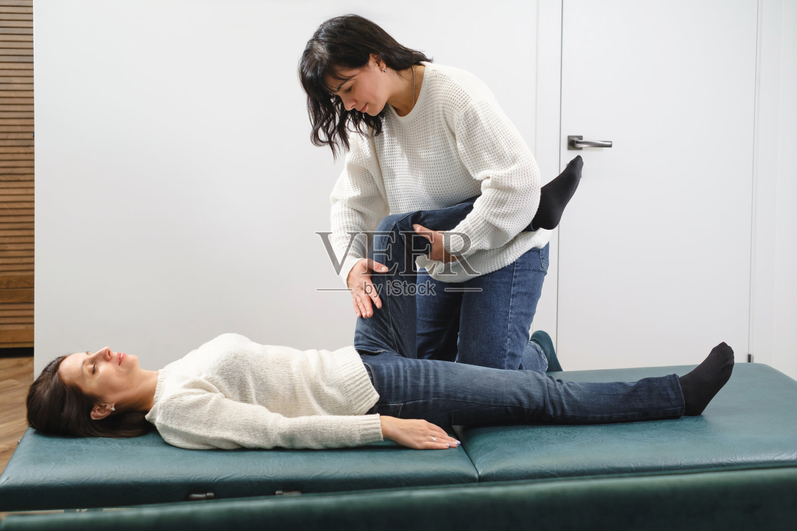 膝盖治疗。物理治疗师为受伤的关节进行膝盖治疗照片摄影图片