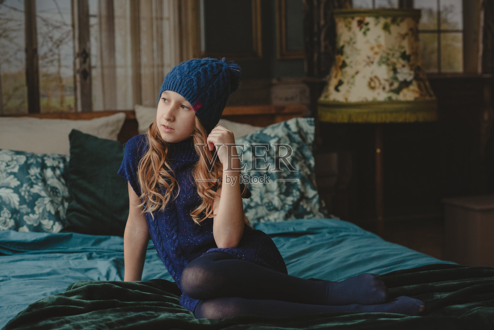 小女孩想。公寓里的肖像。照片摄影图片