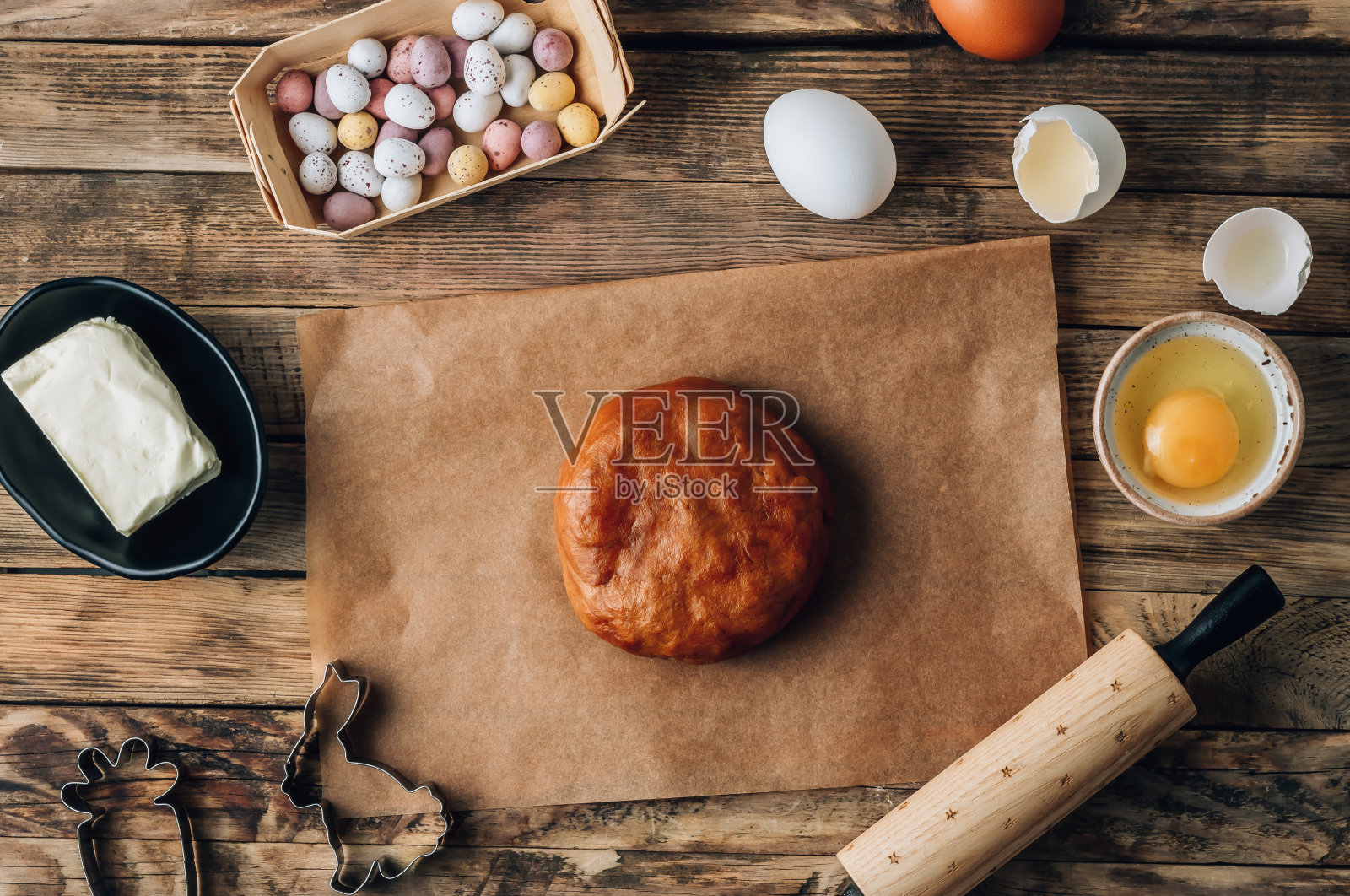 用黑蜂蜜面团切出复活节兔子形状的复活节姜饼。面团，擀面杖和不同的复活节饼干切割机照片摄影图片