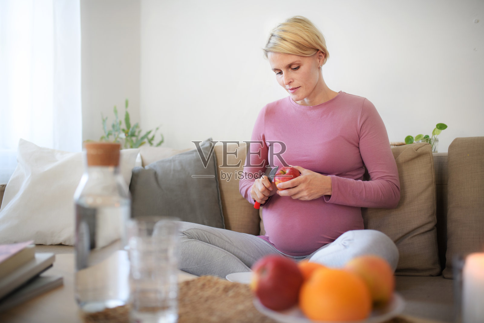 孕妇切苹果的高角度视角。照片摄影图片