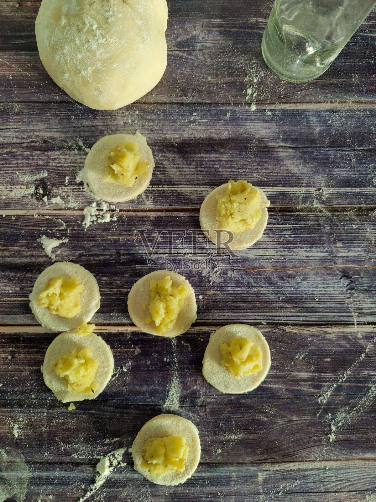 木桌上有土豆馅的面团圈照片摄影图片