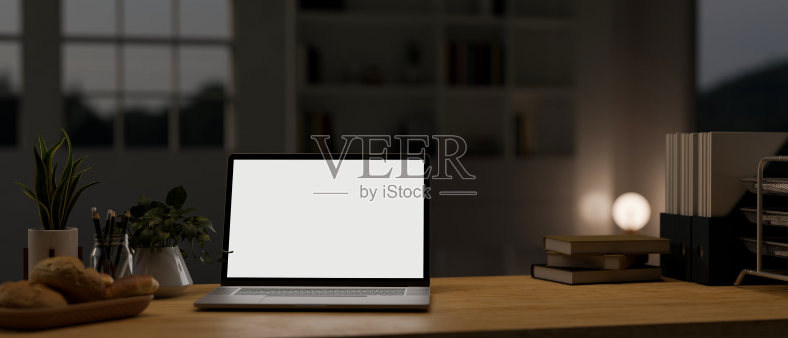 笔记本电脑模型和配件在木桌面在现代黑暗的家庭办公室在晚上。照片摄影图片