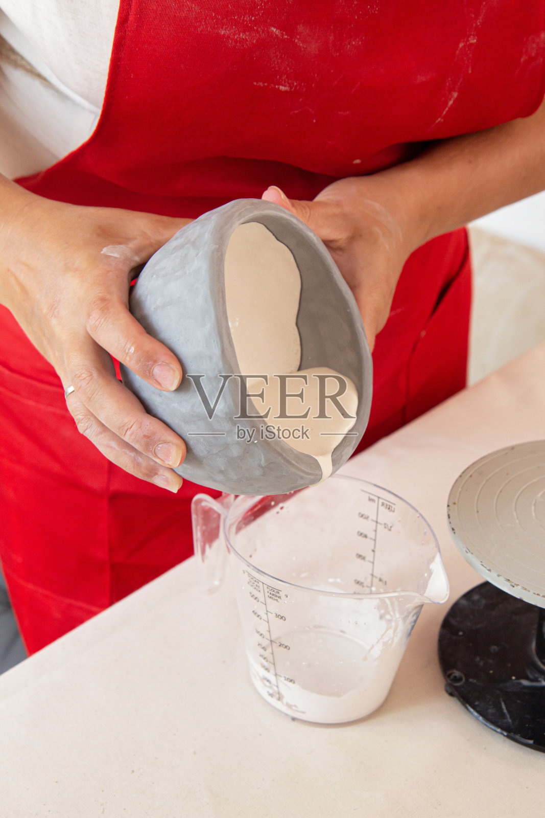 女陶工在工作过程中。裁剪的图像，一个无法识别的女性陶器工人与粘土工作照片摄影图片