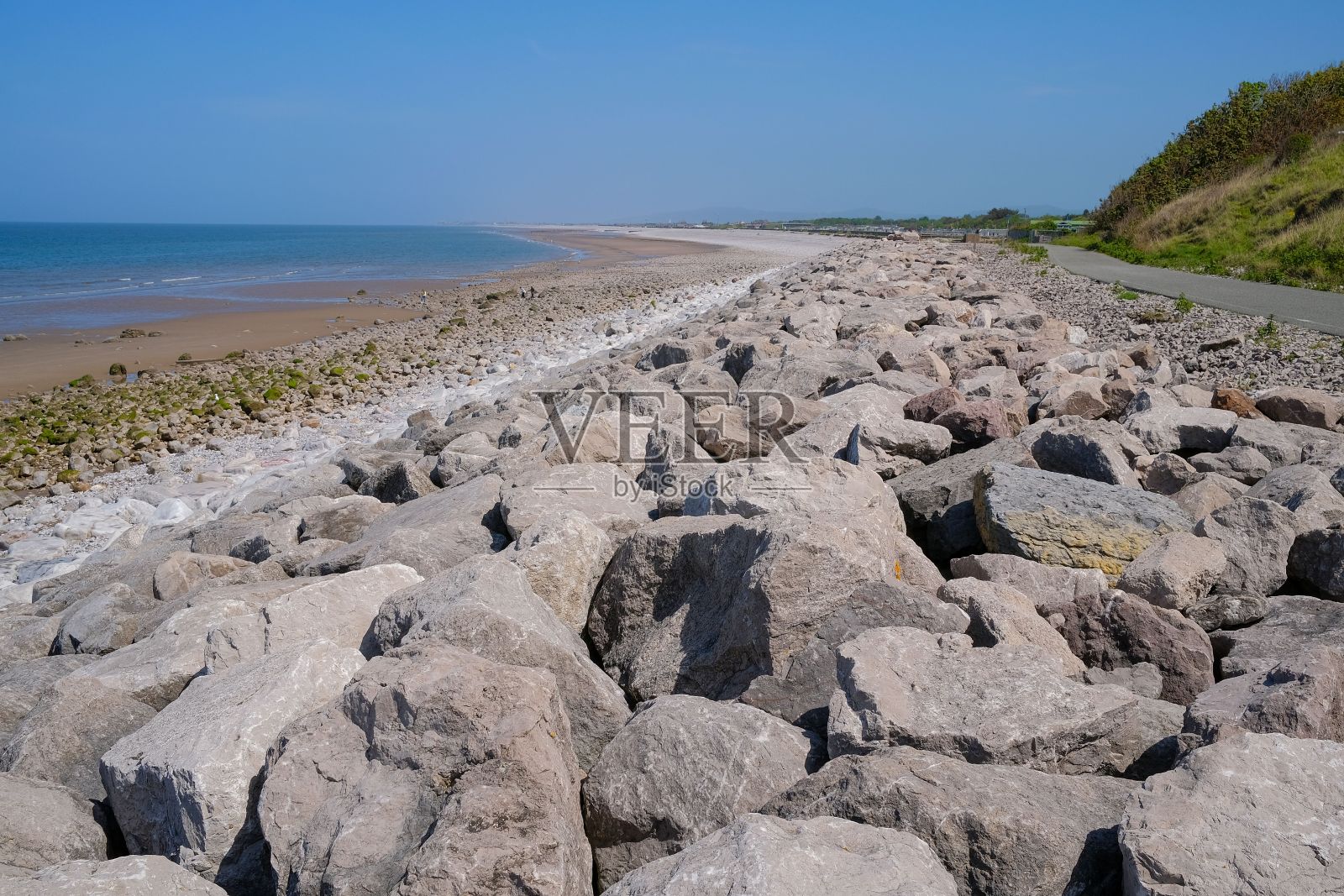 海岸线上的岩石在蔚蓝的天空下照片摄影图片