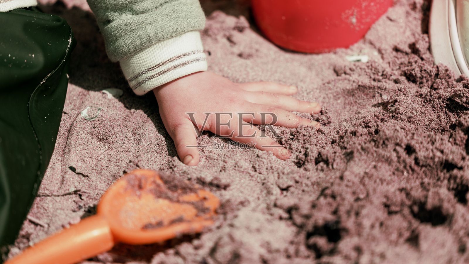 一个孩子玩沙子和玩具的特写镜头照片摄影图片