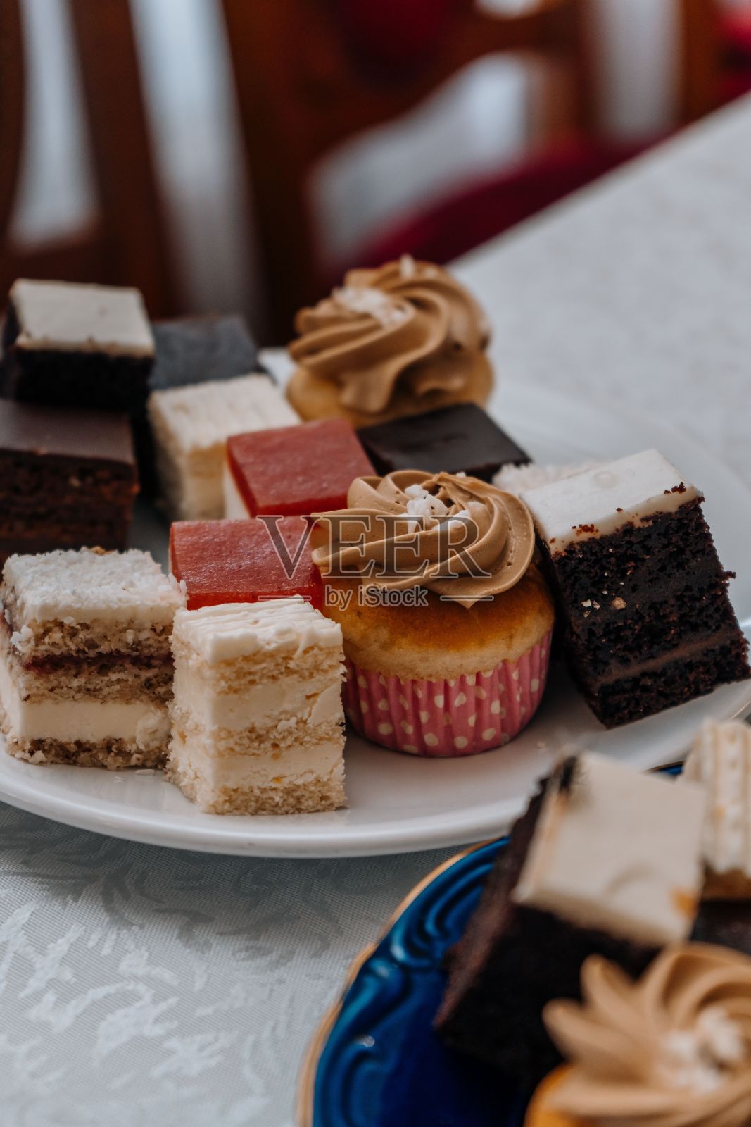 各种各样的蛋糕块切成立方体，放在盘子里照片摄影图片