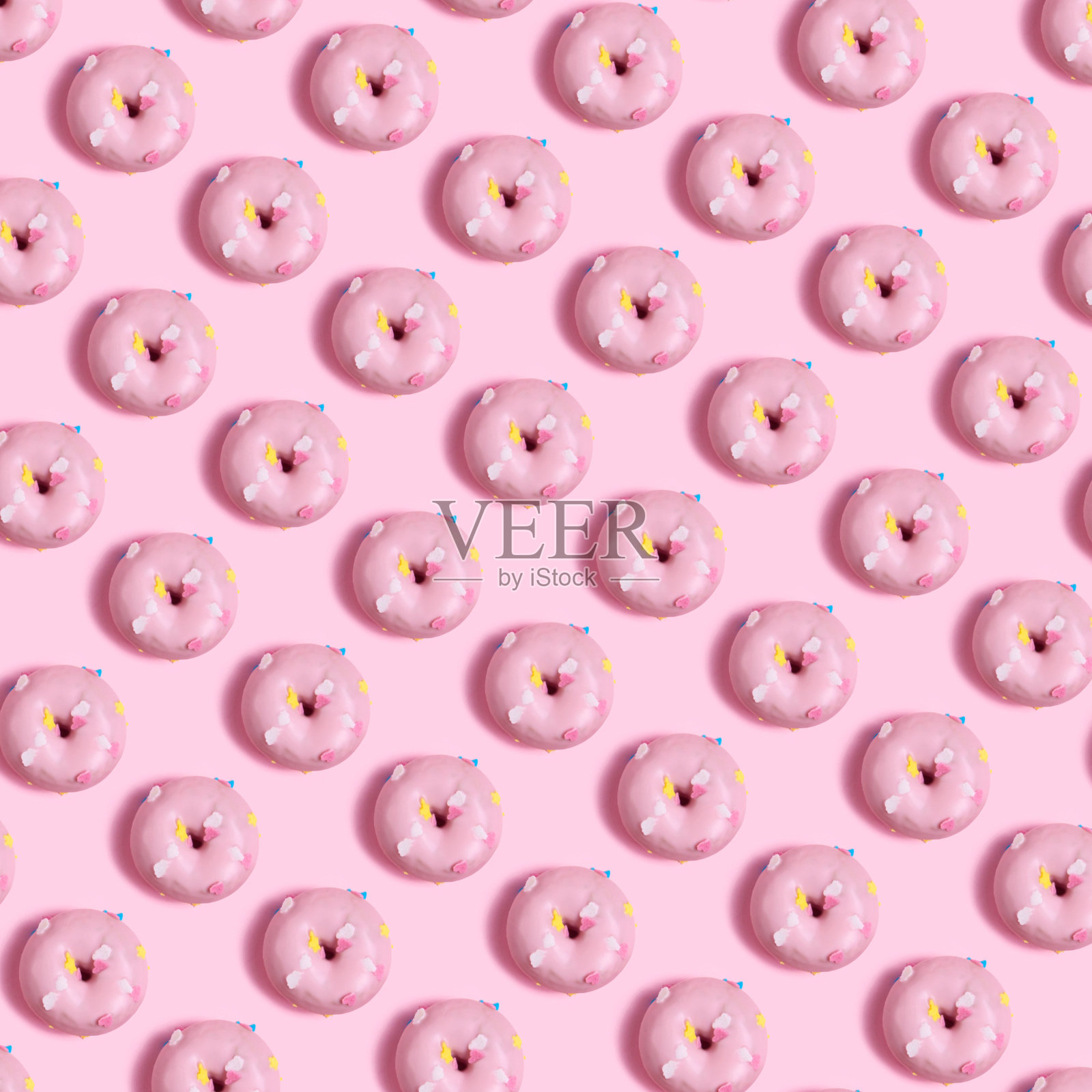 粉红色甜甜圈的无缝模式在浅粉色的背景照片摄影图片