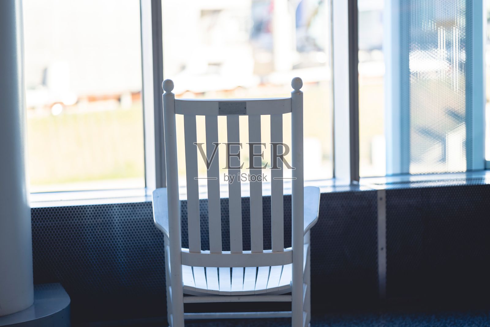 窗户旁的一把白色木制摇椅照片摄影图片