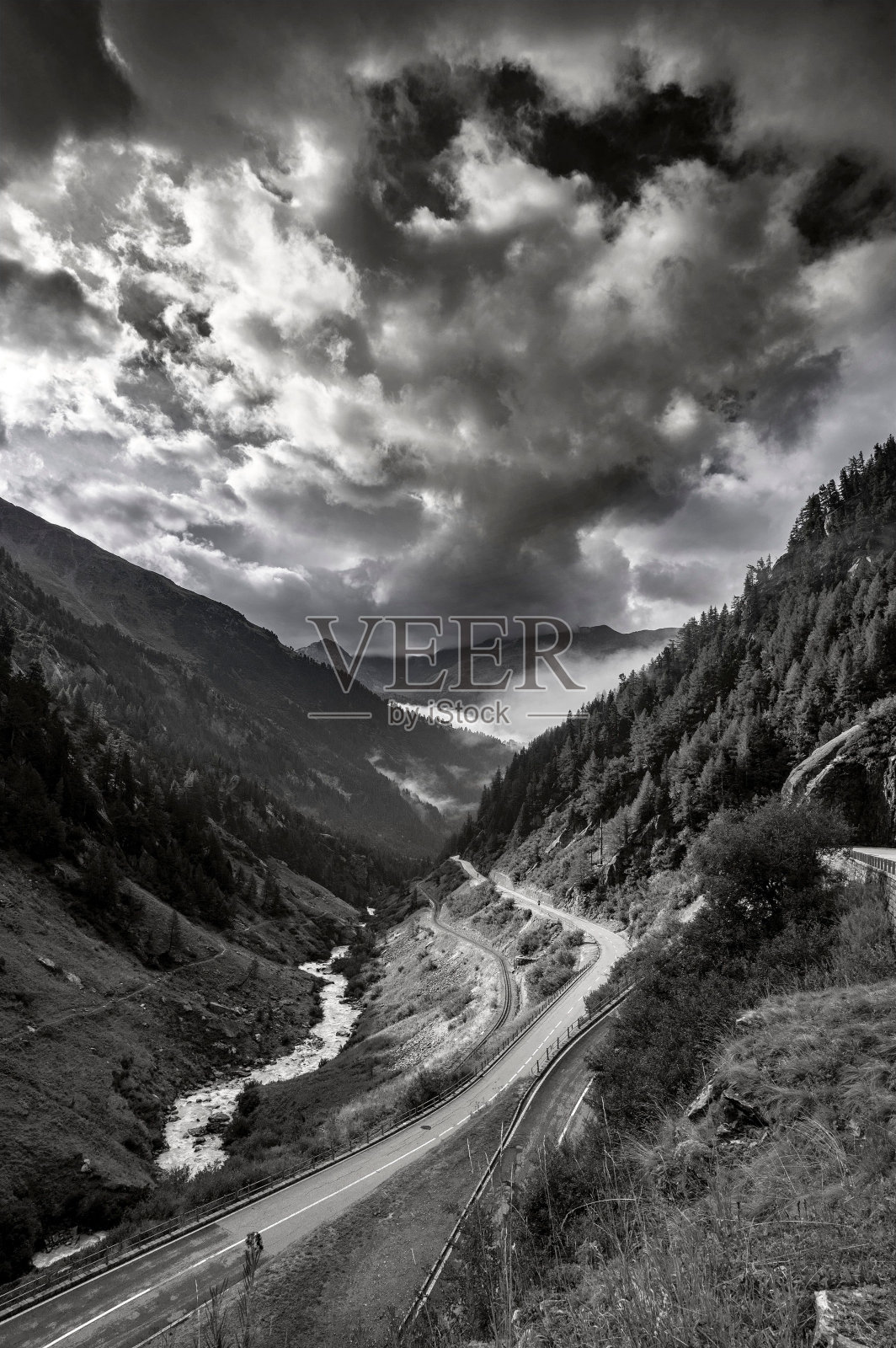 这是一条流经瑞士富尔卡帕斯山脉的河流的垂直灰度照片照片摄影图片