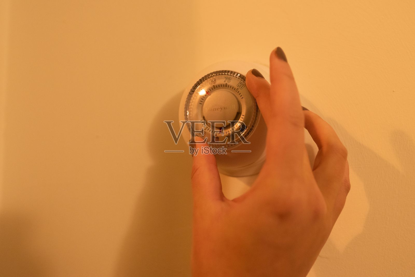 女性为了省钱而更换恒温器照片摄影图片