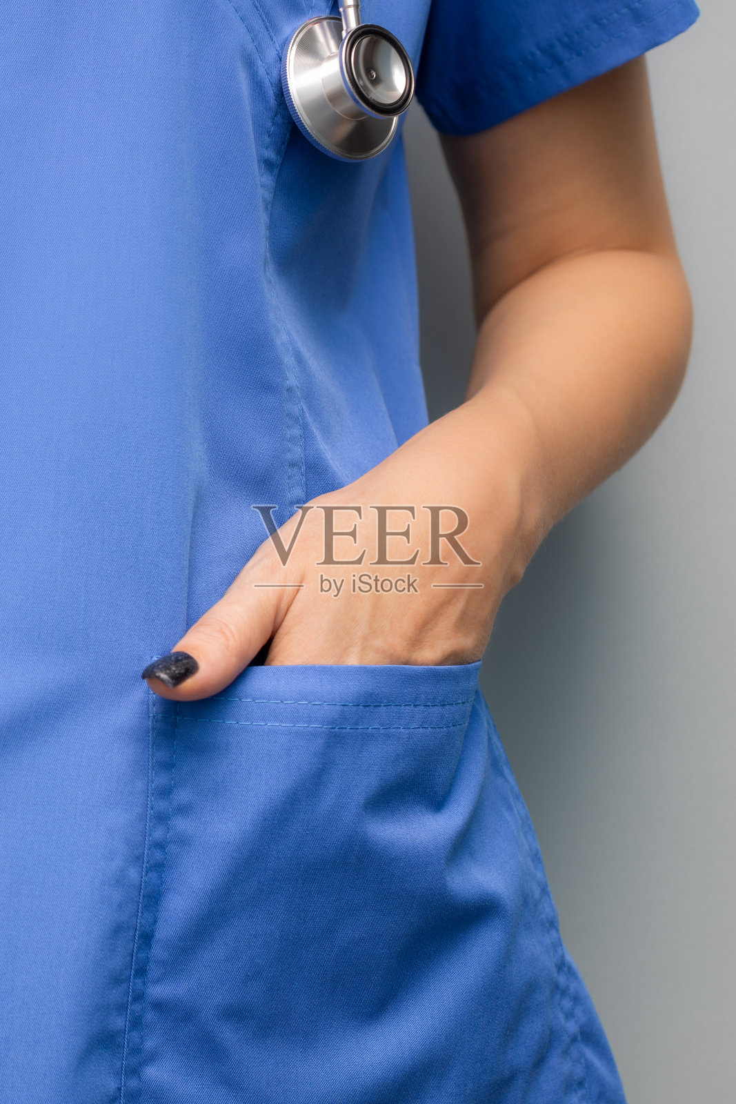 医生站在那里，手插在制服口袋里。照片摄影图片