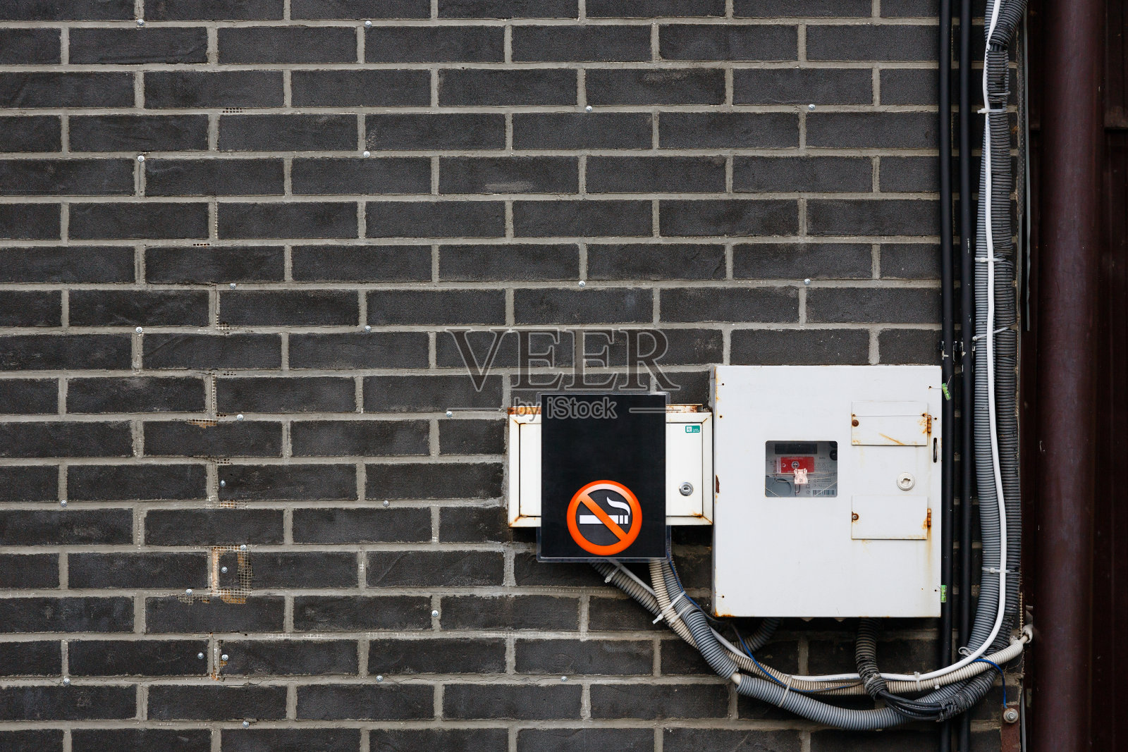 数字电表。墙上有电表和禁止吸烟的标志。用电量的概念和用电量的审计照片摄影图片