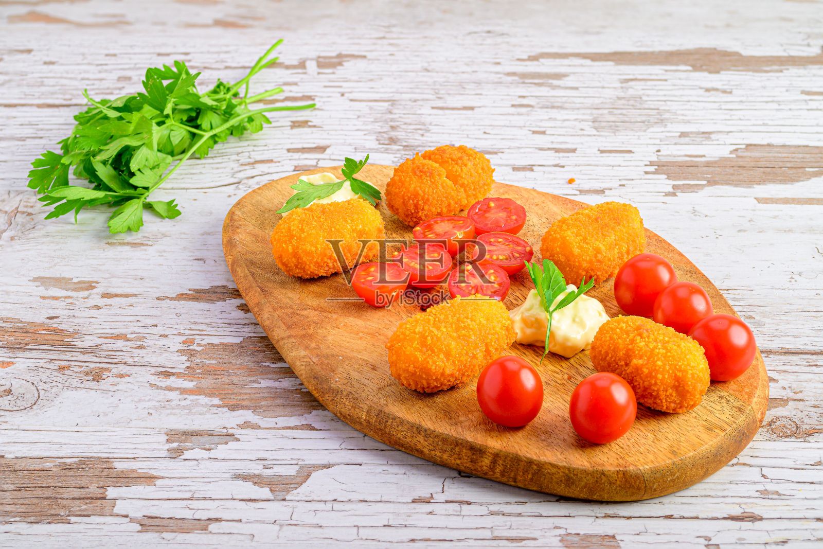 在木板上放着圣女果的炸丸子的特写镜头照片摄影图片