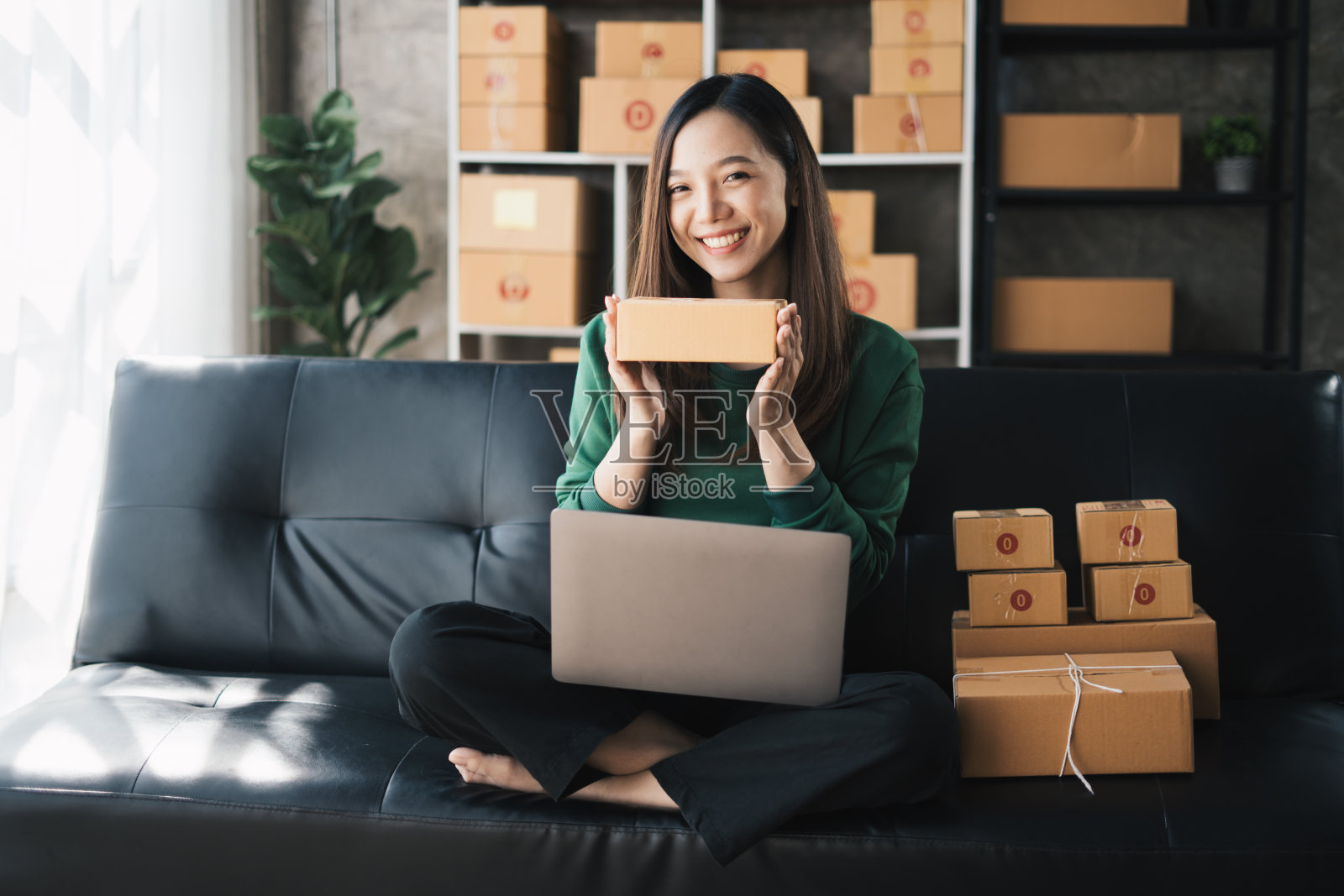 创业时，中小企业女老板在网上查订单，准备打包一箱商品卖给客户，中小企业经营思路。照片摄影图片