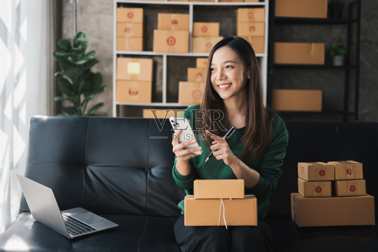 创业时，中小企业女老板在网上查订单，准备打包一箱商品卖给客户，中小企业经营思路。照片摄影图片