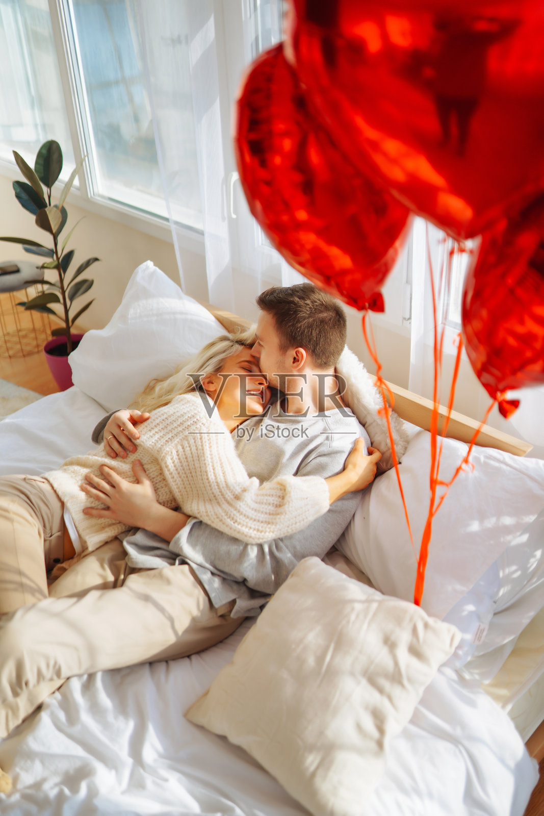 年轻美丽的情侣清晨在床上拥抱。浪漫的一天。照片摄影图片